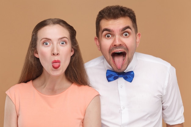 Photo couple looking at camera avec de grands yeux étonnés face et langue