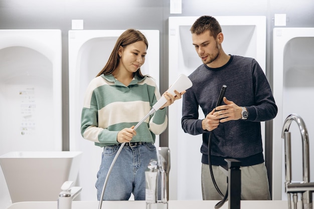 Couple en magasin choisissant un mitigeur de salle de bain