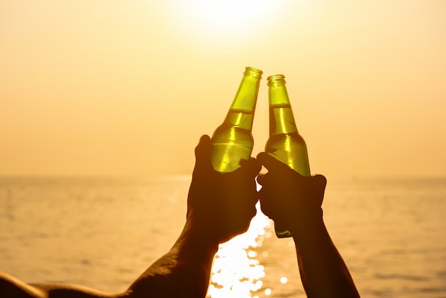 Couple, mains, tenue, bouteilles bière, cliquetis, plage, coucher soleil été