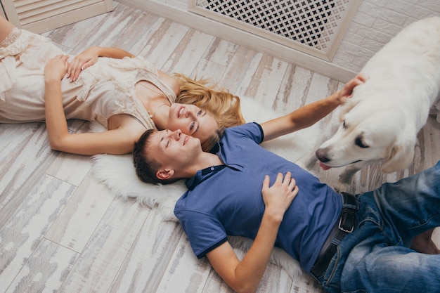 Couple à la maison allongé sur le sol avec son chien