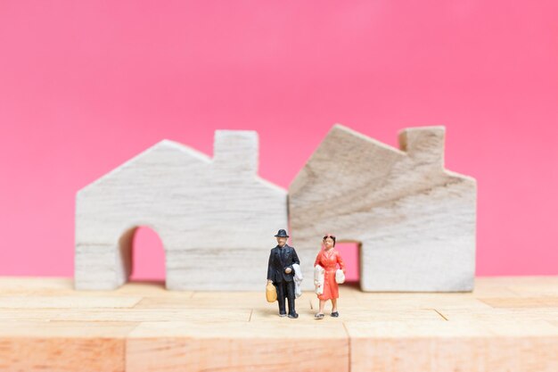 Couple avec une maison sur fond rose