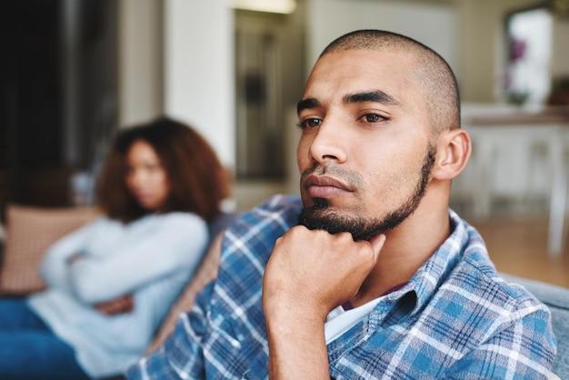 Couple malheureux après une dispute avec un mari frustré et triste regardant loin de sa femme à la maison Petit ami déprimé et distant assis sur le canapé après s'être battu avec sa petite amie