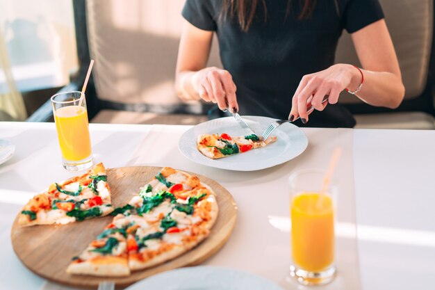 Un couple mange de la pizza dans un restaurant.