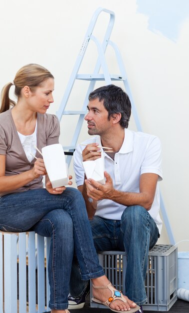 Couple mangeant pendant la rénovation de leur nouvelle maison