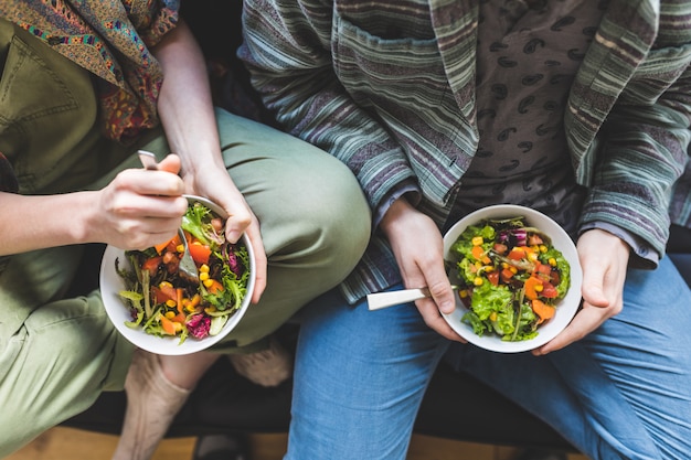 Couple, manger sainement, salade, maison, sofa