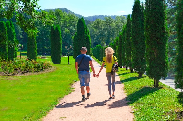 Couple marchant dans le parc main dans la main, famille conceptuelle et symbolique