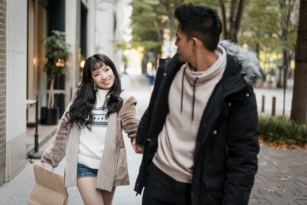 Photo couple marchant dans la rue avec sac à provisions