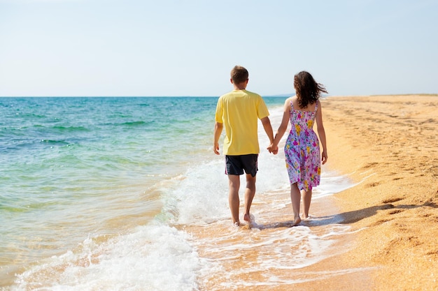 Un couple marchant sur la plage main dans la main