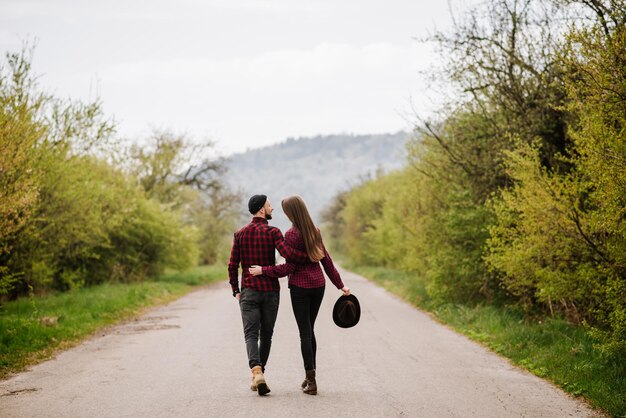 Un couple marchant sur la route à la campagne Vue arrière