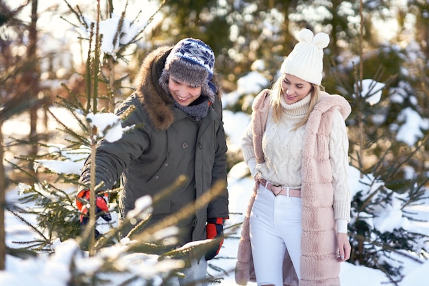 Couple sur le marché des arbres de Noël en hiver. photo de haute qualité