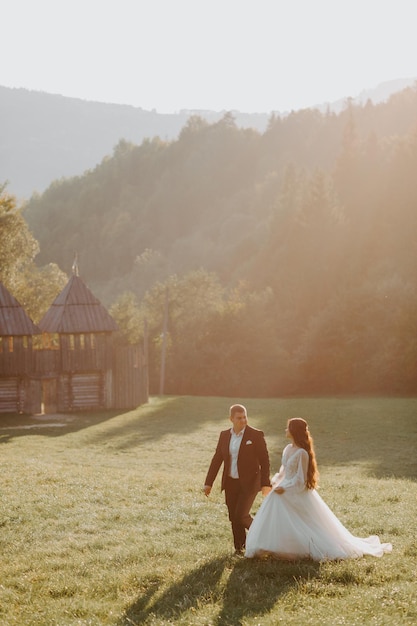 Couple de mariage aimant s'embrasser dans les montagnes au coucher du soleil. Portrait de la mariée et du marié