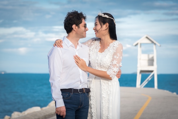 Photo couple de mariage à côté de la mer