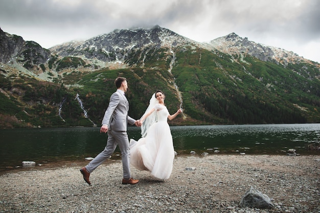 Couple de mariage courir près du lac dans les Tatras en Pologne, Morskie Oko