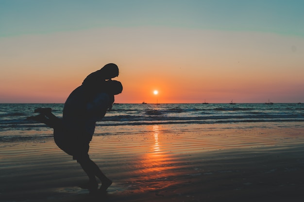 Couple de mariage dans la mer au coucher du soleil