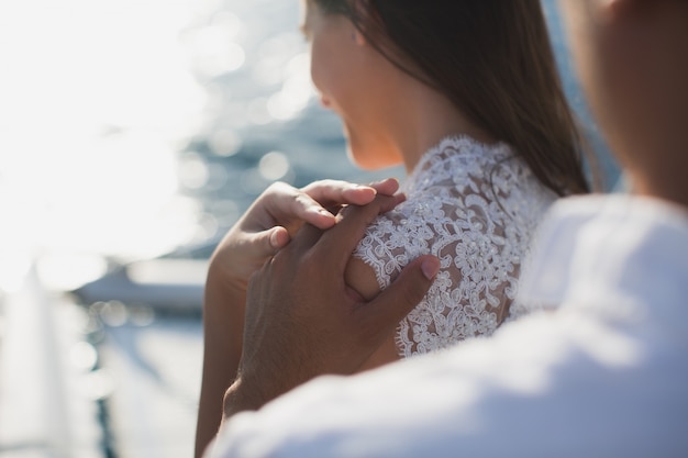 Le couple de mariage est étreignant sur un yacht. Mariée de beauté avec le marié.