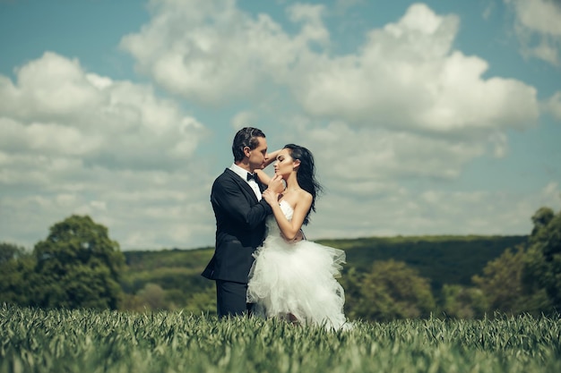 Couple de mariage sur l'herbe verte et le ciel bleu