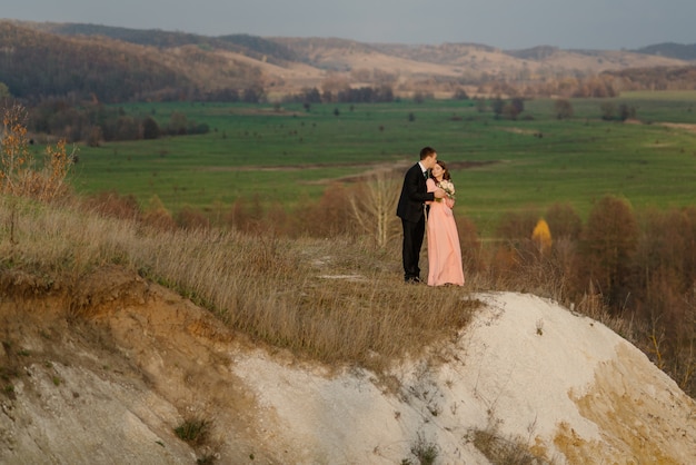 Couple de mariage heureux admirer le magnifique paysage au coucher du soleil.