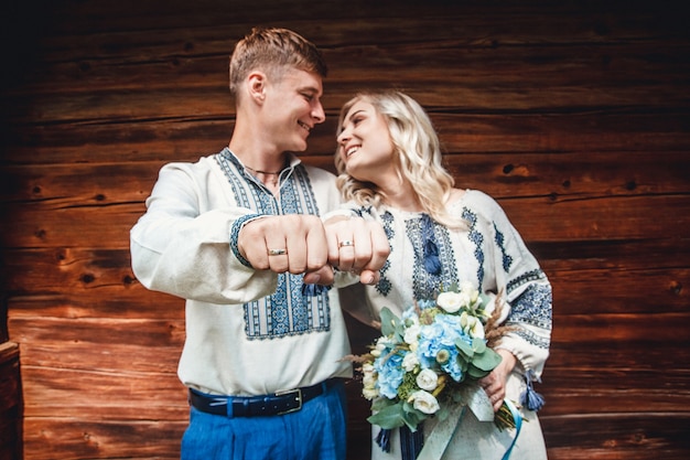 Couple de mariage incroyable dans une chemise brodée avec un bouquet de fleurs