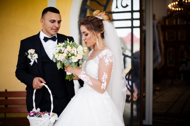 Le couple de mariage à l'intérieur s'embrasse. Fille de beau modèle en robe blanche. Homme en costume. Mariée beauté avec marié