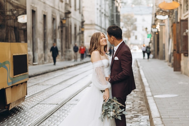 Un couple de mariage international, une mariée européenne et un marié asiatique, se promènent ensemble dans la ville