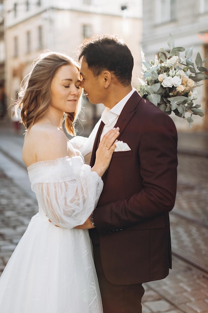 Un couple de mariage international, une mariée européenne et un marié asiatique, se promènent ensemble dans la ville