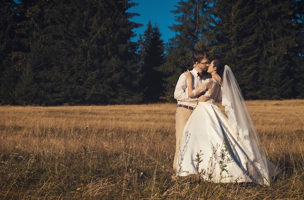 Couple de mariage. Jeunes mariés en forêt, heure d'été.