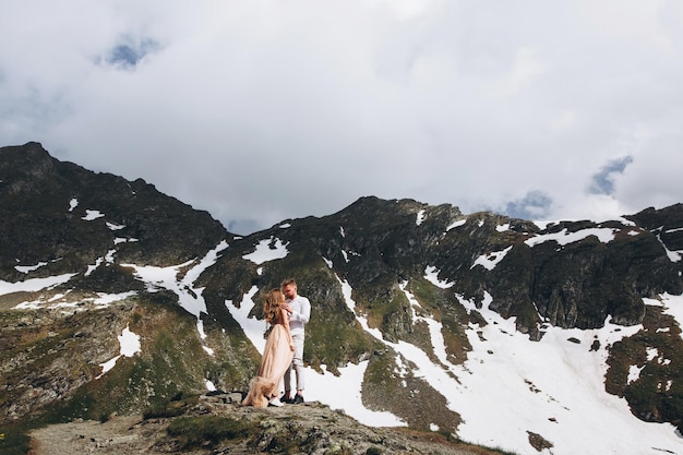 Couple de mariage marchant dans les montagnes avec une vue imprenable