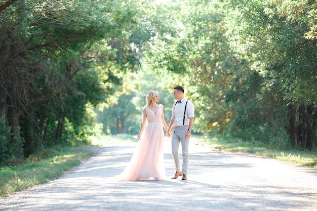 Couple de mariage sur la nature en journée d'été. la mariée et le marié étreignant au mariage.