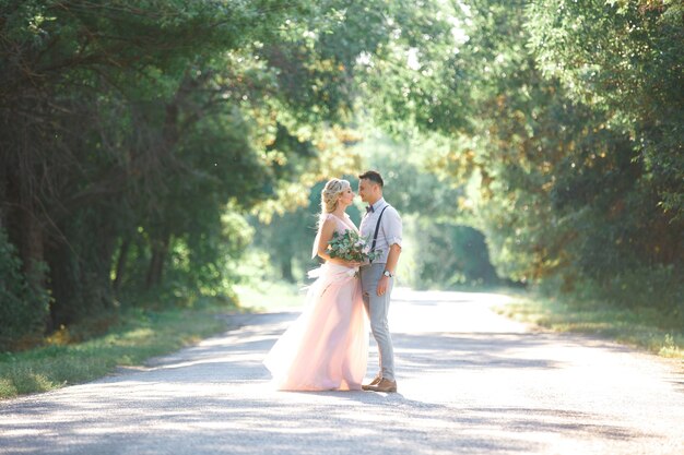 Couple de mariage sur la nature en journée d'été. la mariée et le marié étreignant au mariage.