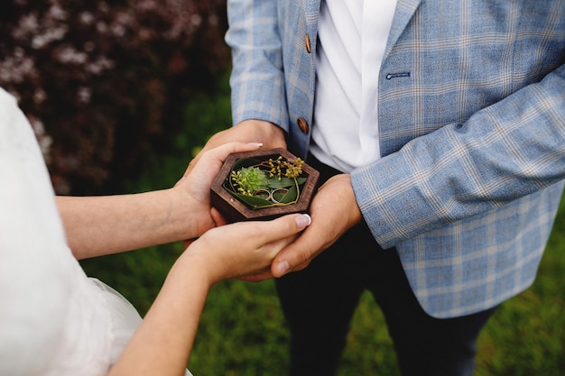 Le couple de mariage tient leurs anneaux de mariage. Photo de haute qualité