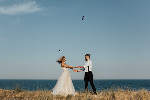 Le couple de mariage tourne sur la plage de la mer.