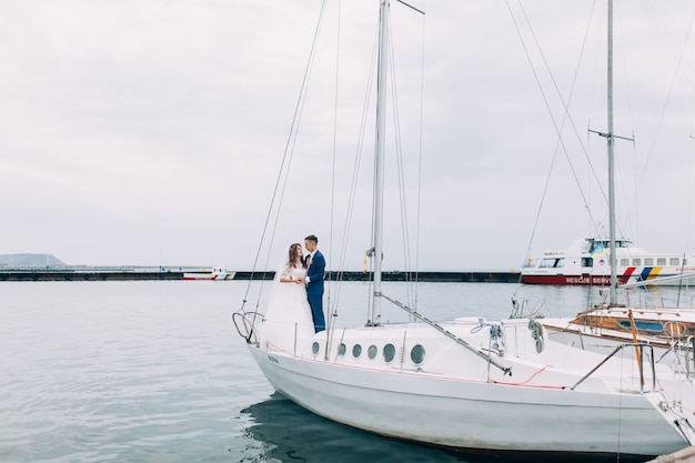 Couple de mariage sur le yacht, amoureux posant sur le yacht