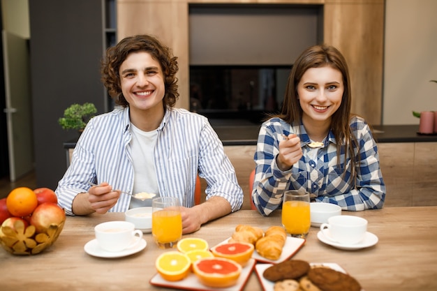 Couple marié amoureux prenant le petit déjeuner ensemble le matin à la cuisine