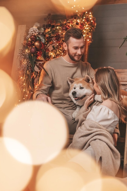 Un couple marié authentique et authentique passe du temps avec un chien japonais au pavillon de Noël