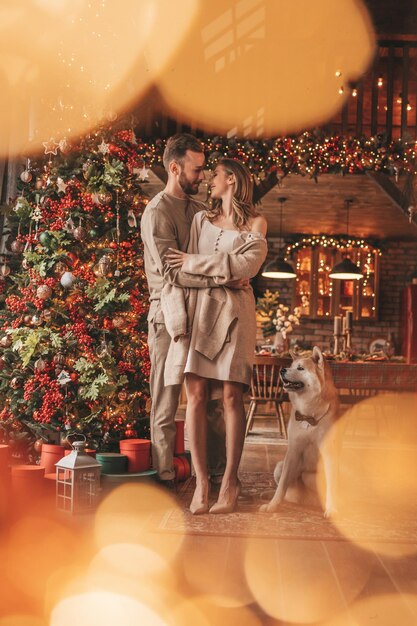 Un couple marié authentique et authentique passe du temps avec un chien japonais au pavillon de Noël