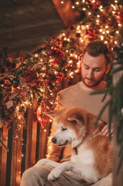 Un couple marié authentique et authentique passe du temps avec un chien japonais au pavillon de Noël