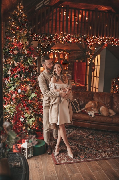 Un couple marié authentique et authentique passe du temps avec un chien japonais au pavillon de Noël