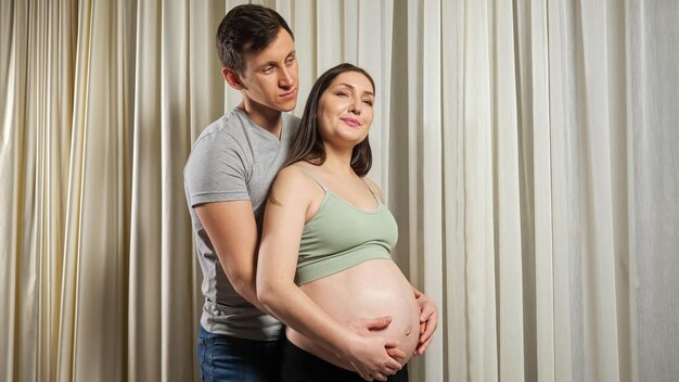 Couple marié câlins caressant le ventre nu enceinte avec amour