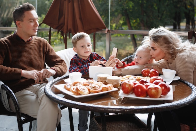 Couple marié avec enfants, fille et fils à une table dans un café. Heureux couple traditionnel, bonheur familial.