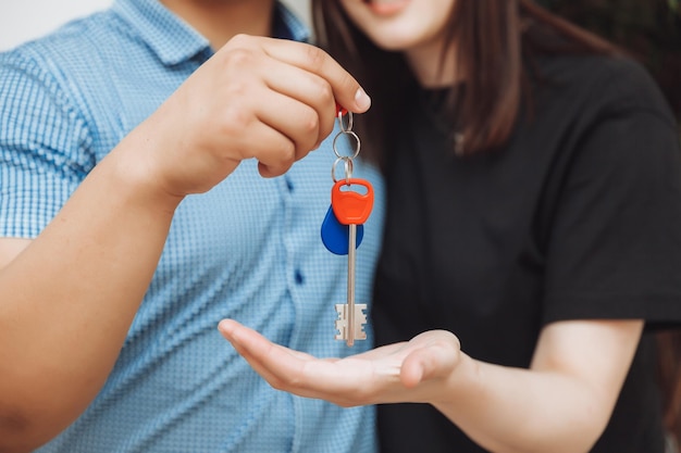 Un couple marié heureux célèbre son déménagement dans une nouvelle maison montre les clés se trouve dans un appartement le concept d'une hypothèque sur l'immobilier en gros plan