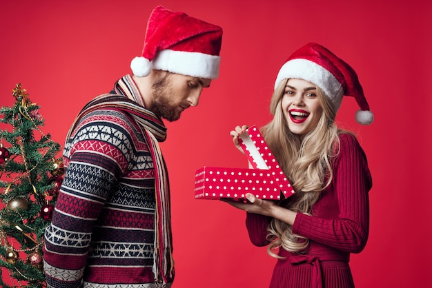 couple marié heureux décoration de vacances de Noël cadeaux fond rouge photo de haute qualité