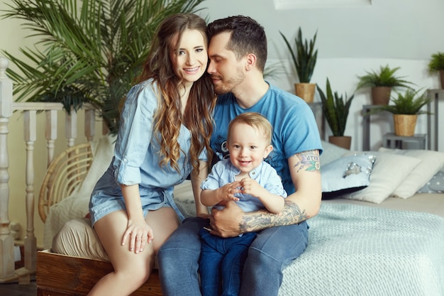 Couple marié et leur petit bébé dans ses bras. Jeune famille à la maison le matin le jour de congé