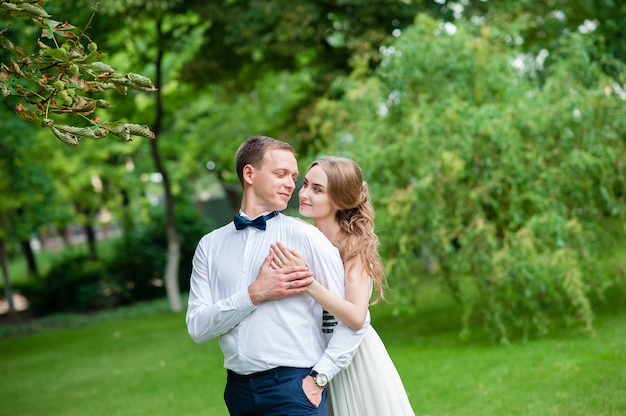 couple marié marche et se fait des câlins dans le parc.