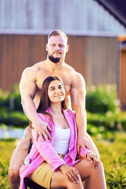 Un couple marié pose pour une photo sur la pelouse de leur jardin.