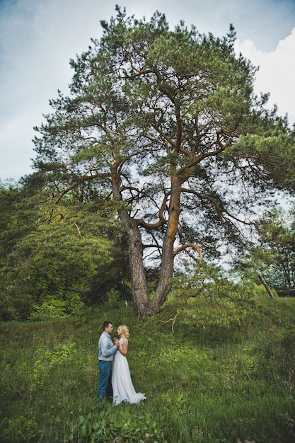 Couple marié près d'un arbre dans la nature