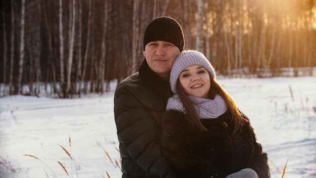 Un couple marié s'embrassant à l'extérieur en hiver près de la forêt