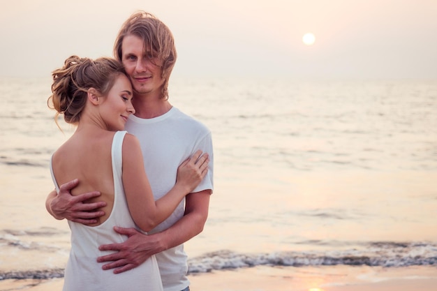 Couple marié s'exécutant sur une plage de sable