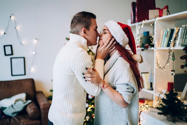 Couple marié se préparant à s'embrasser les yeux fermés à Noël