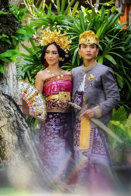 Photo un couple de mariés dans des vêtements traditionnels baliens