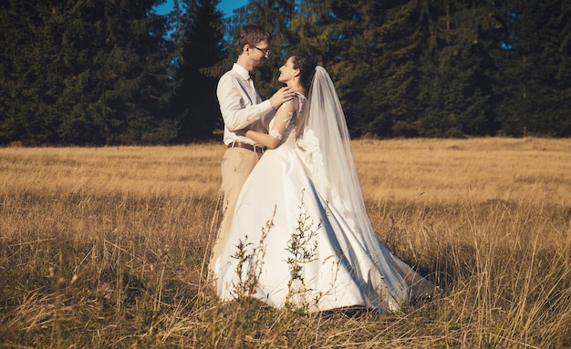 Le couple de mariés, la mariée et le marié dans la forêt en été.